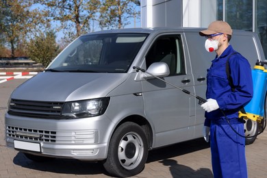 Photo of Pest control worker with spray tank outdoors