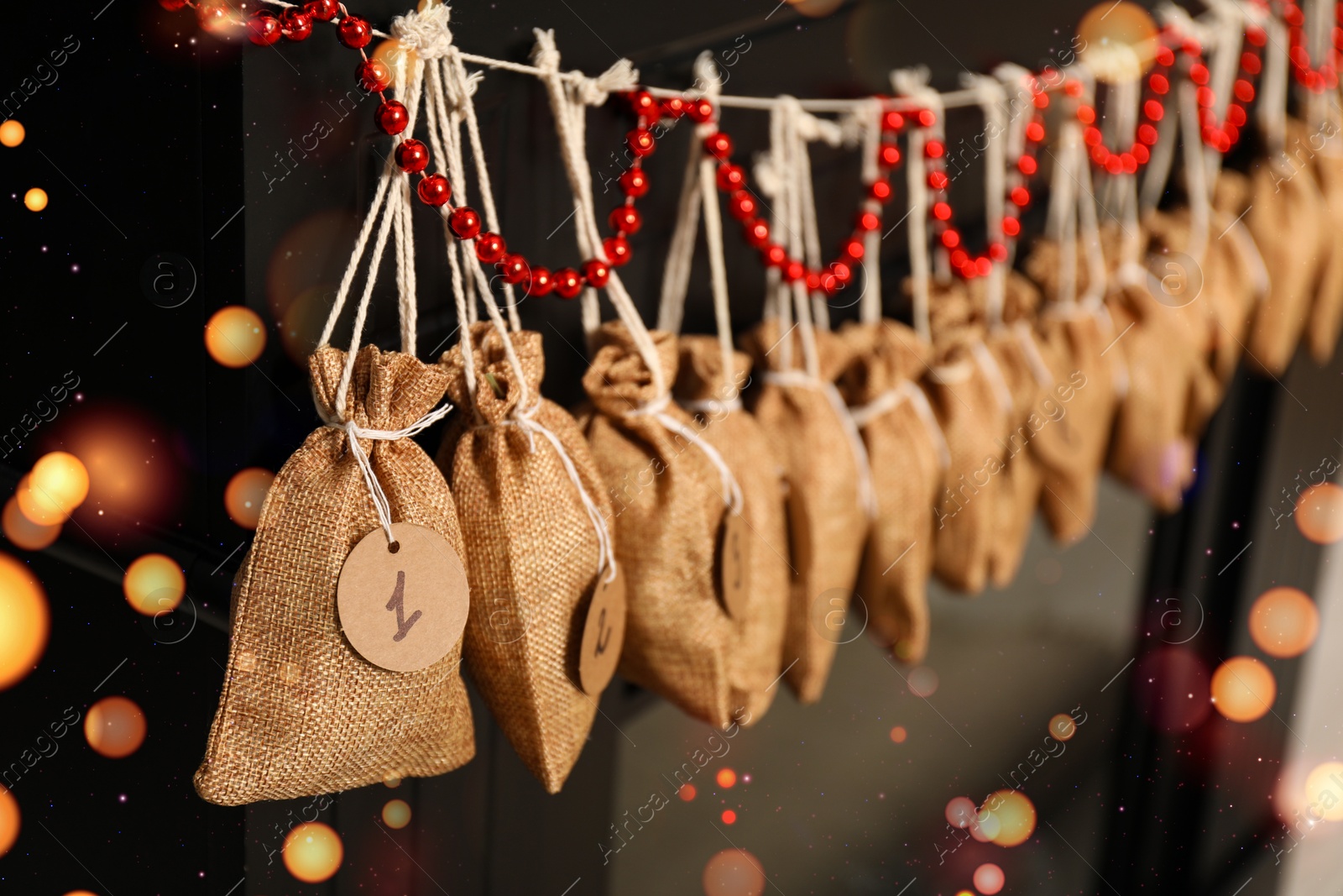 Photo of Christmas advent calendar with gifts and decor hanging on fireplace indoors, closeup