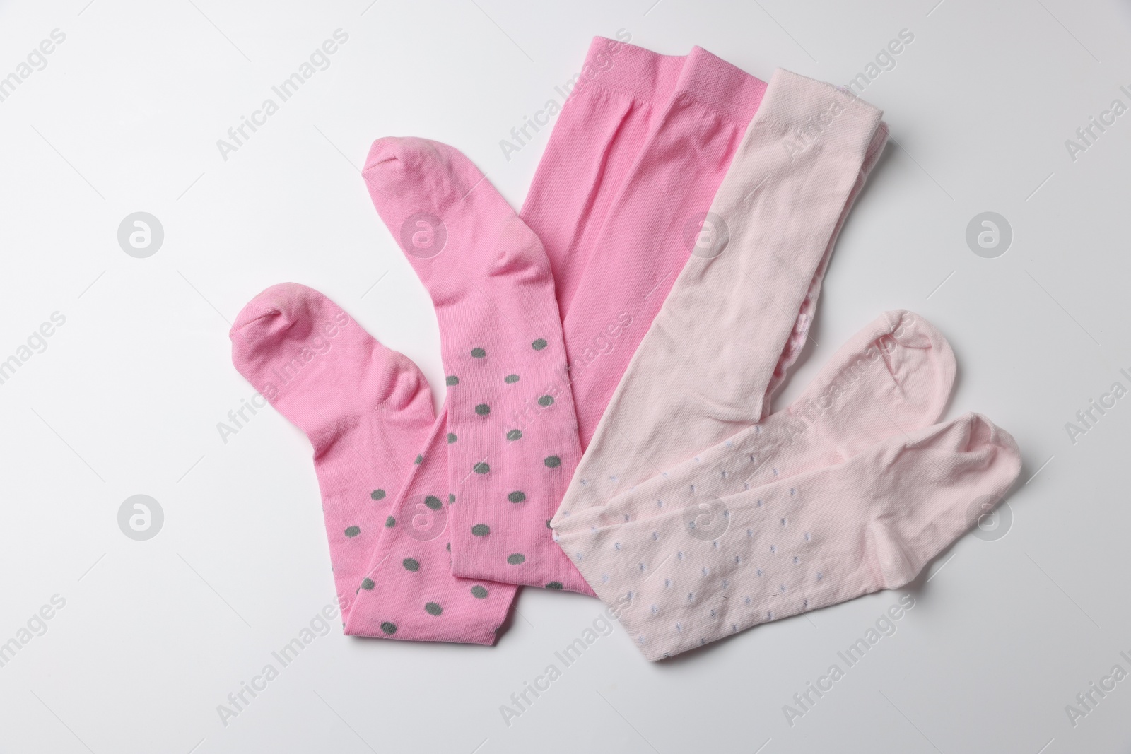 Photo of Beautiful pink child's tights on white background, top view