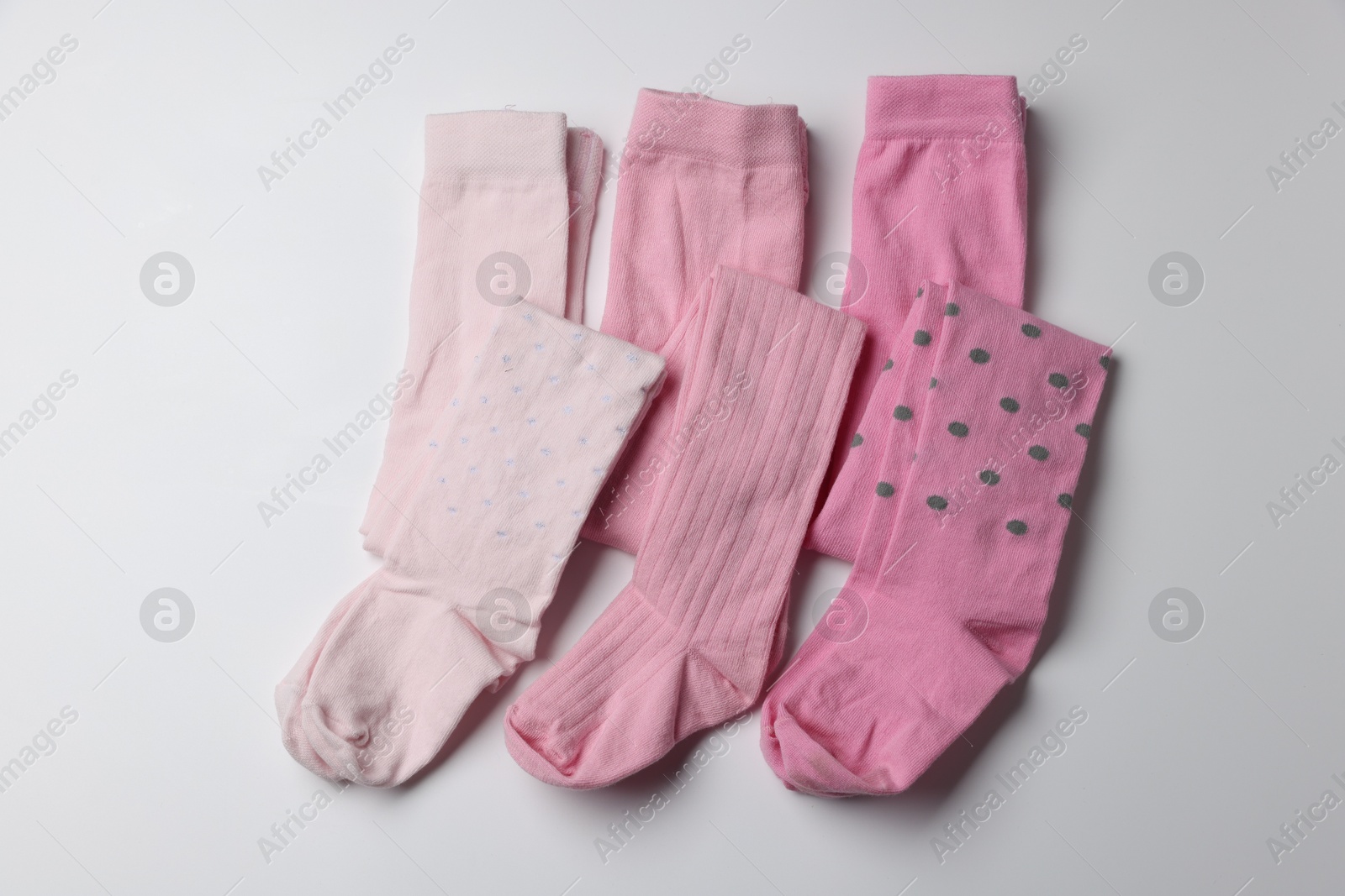 Photo of Beautiful pink child's tights on white background, top view