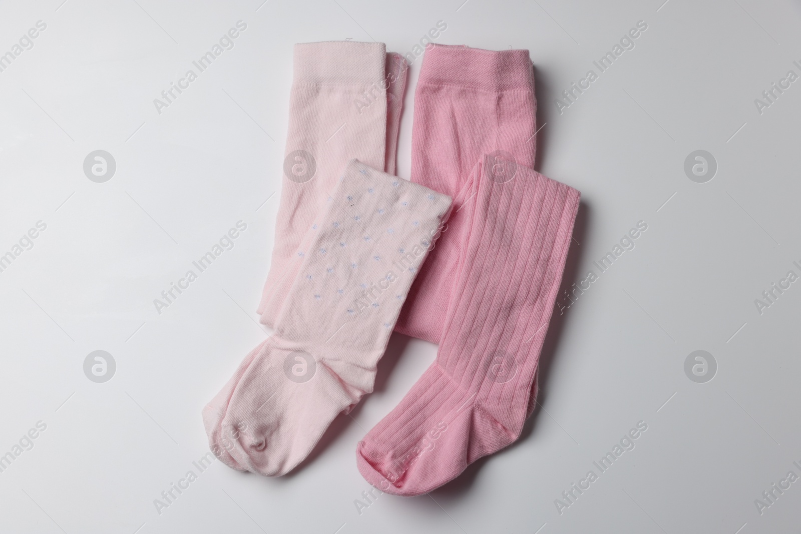 Photo of Beautiful pink child's tights on white background, top view