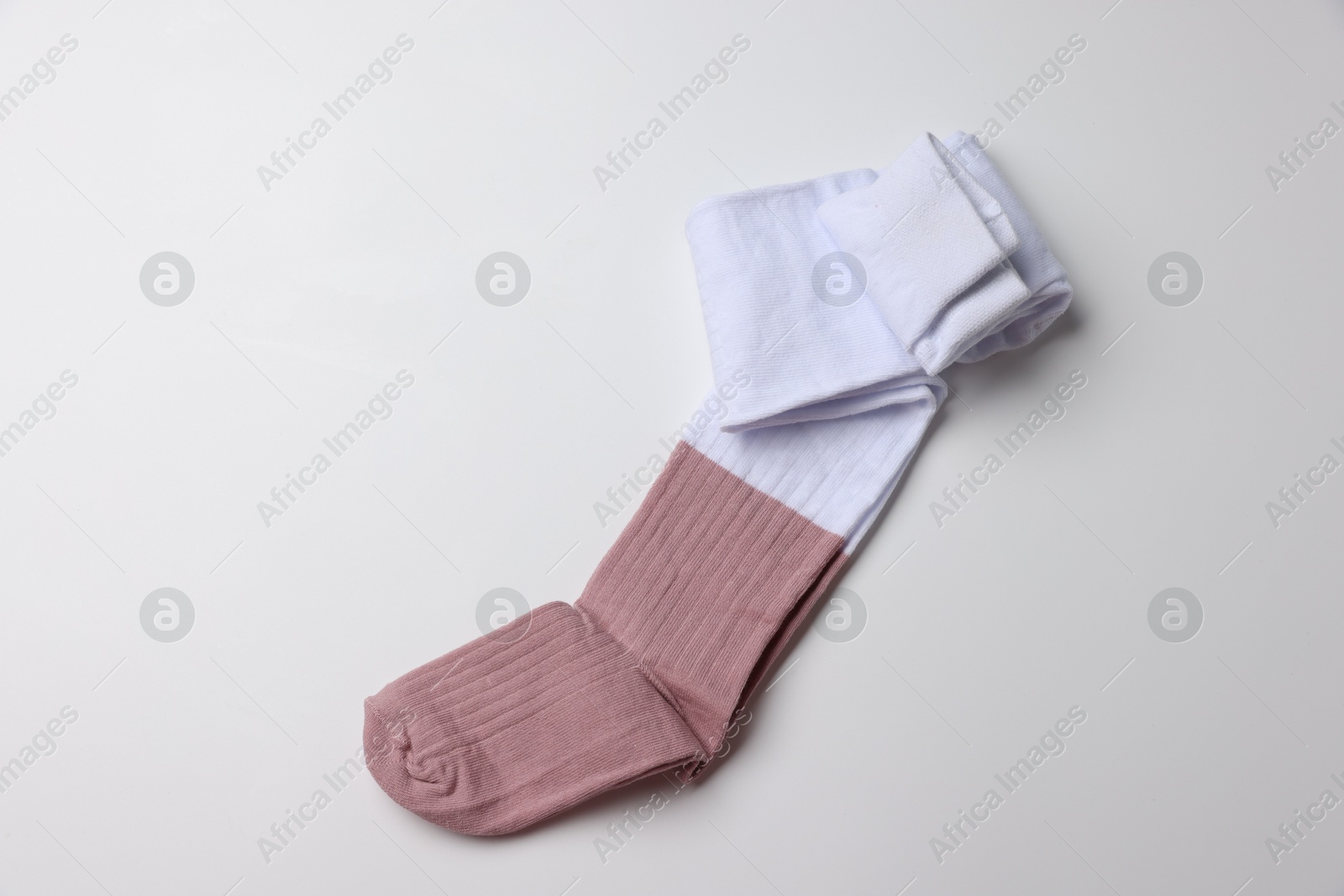 Photo of Beautiful child's tights on white background, top view