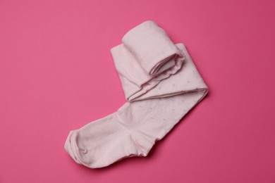 Photo of Beautiful child's tights on pink background, top view