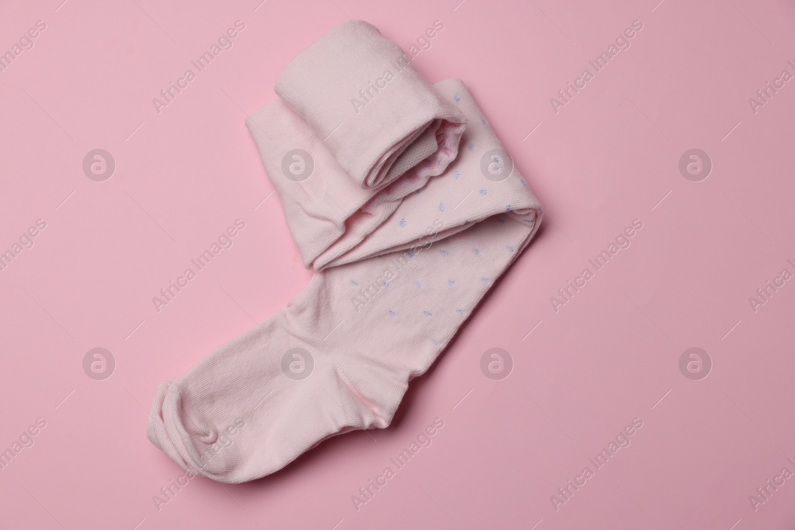 Photo of Beautiful child's tights on pink background, top view