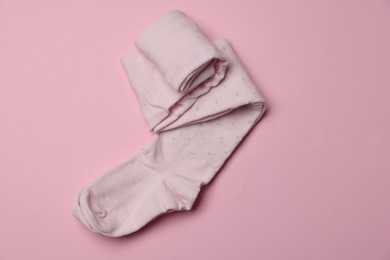 Photo of Beautiful child's tights on pink background, top view