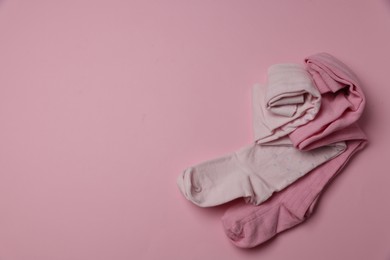 Photo of Beautiful child's tights on pink background, top view. Space for text