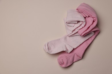 Photo of Beautiful pink child's tights on beige background, top view. Space for text