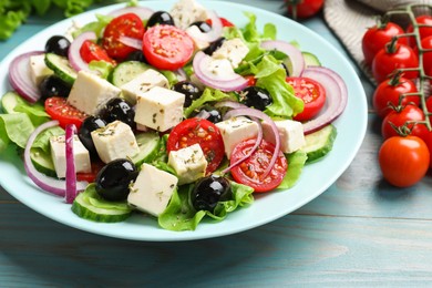 Photo of Delicious salad with feta cheese served on blue wooden table, closeup