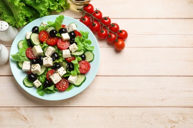 Photo of Delicious salad with feta cheese served on white wooden table, flat lay. Space for text