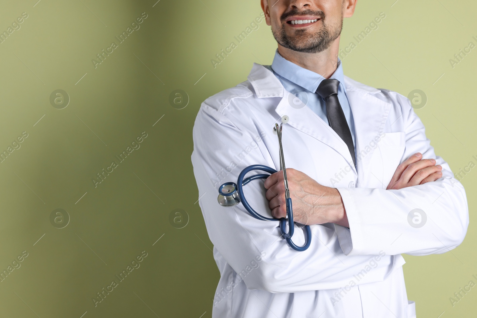 Photo of Doctor with stethoscope on olive background, closeup. Space for text