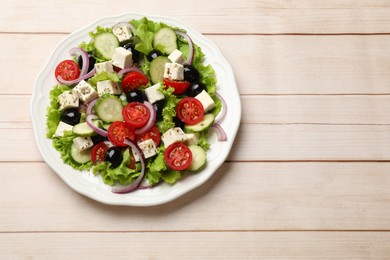 Photo of Delicious salad with feta cheese on wooden table, top view. Space for text