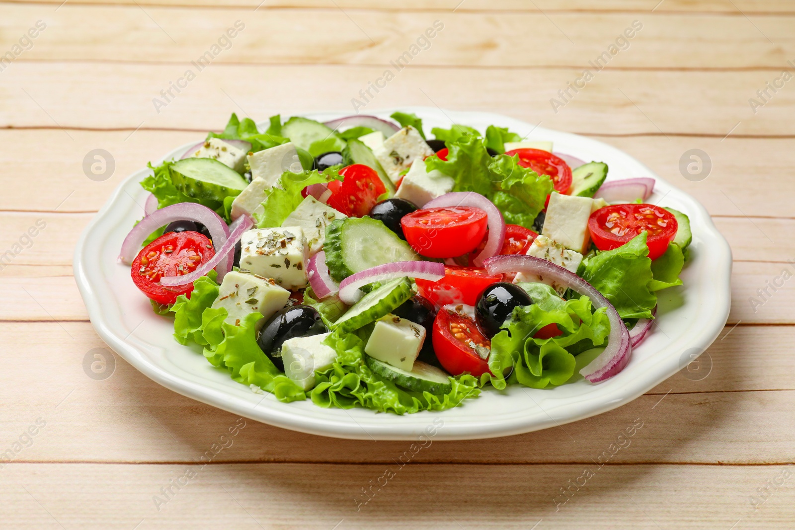 Photo of Delicious salad with feta cheese on wooden table, closeup