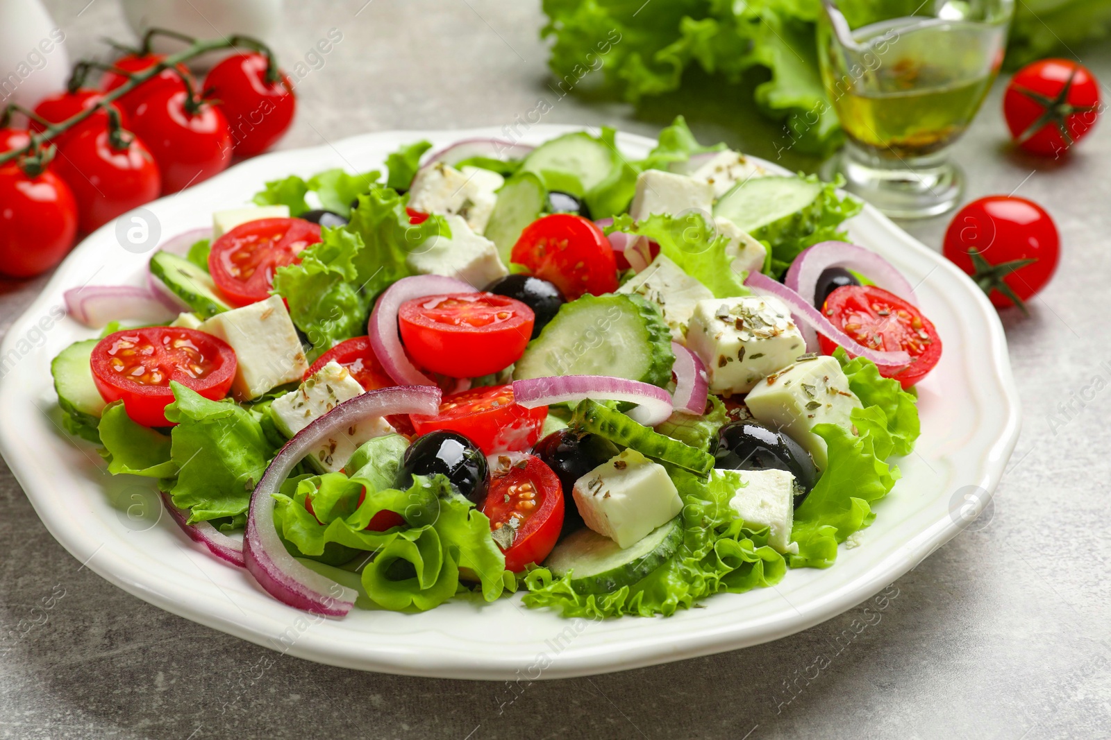 Photo of Delicious salad with feta cheese on gray textured table, closeup