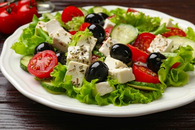 Photo of Delicious salad with feta cheese on wooden table, closeup