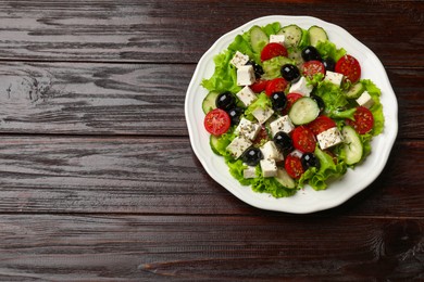 Photo of Delicious salad with feta cheese on wooden table, top view. Space for text