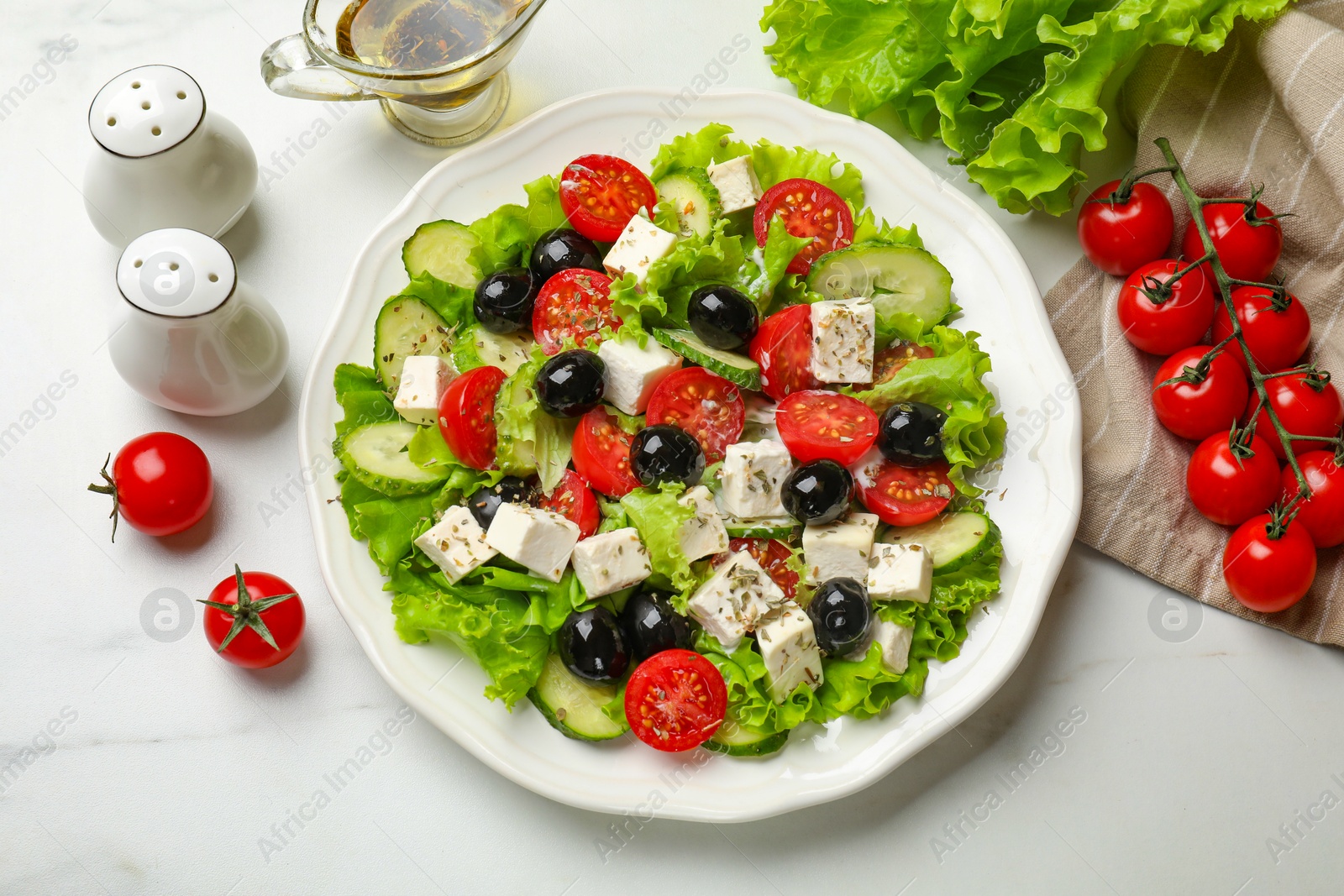 Photo of Delicious salad with feta cheese and ingredients on white table, flat lay