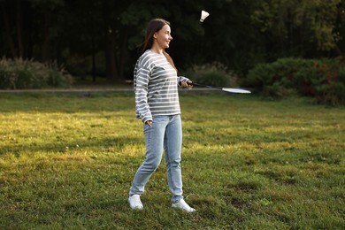 Photo of Young woman playing badminton racket in park