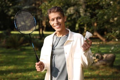 Happy young man with badminton racket and shuttlecock in park