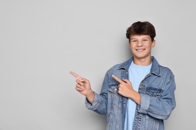 Photo of Happy teenage boy on light grey background, space for text