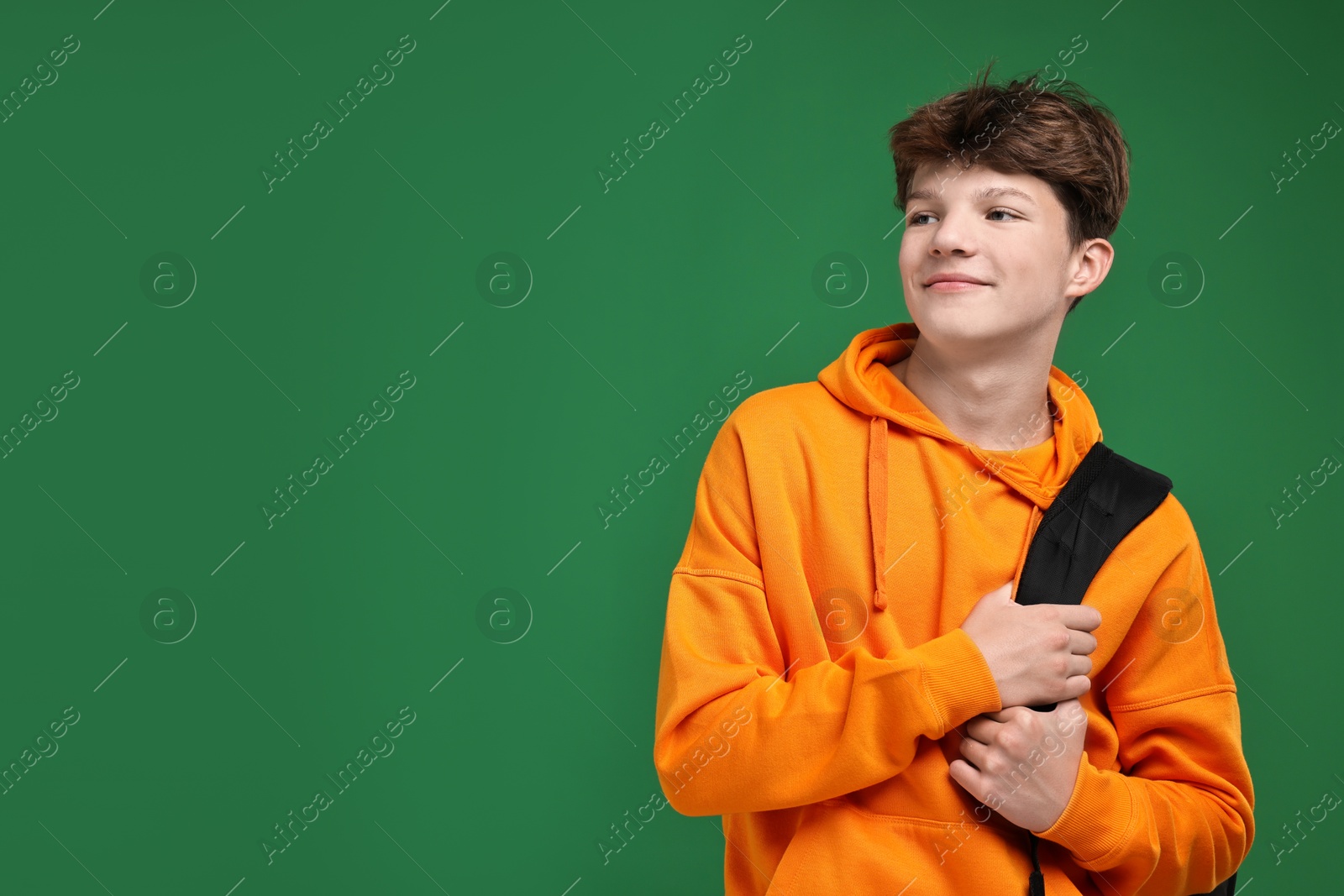 Photo of Teenage boy with backpack on green background, space for text