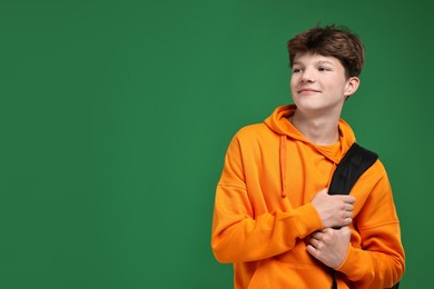 Photo of Teenage boy with backpack on green background, space for text