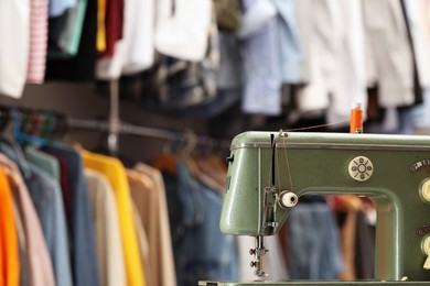 Photo of Vintage sewing machine with thread in workshop. Space for text