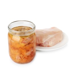 Photo of Canned meat in jar and raw chicken fillet isolated on white