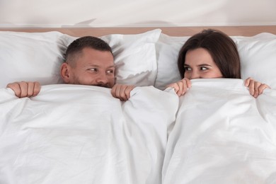 Photo of Lovely couple lying in bed at home