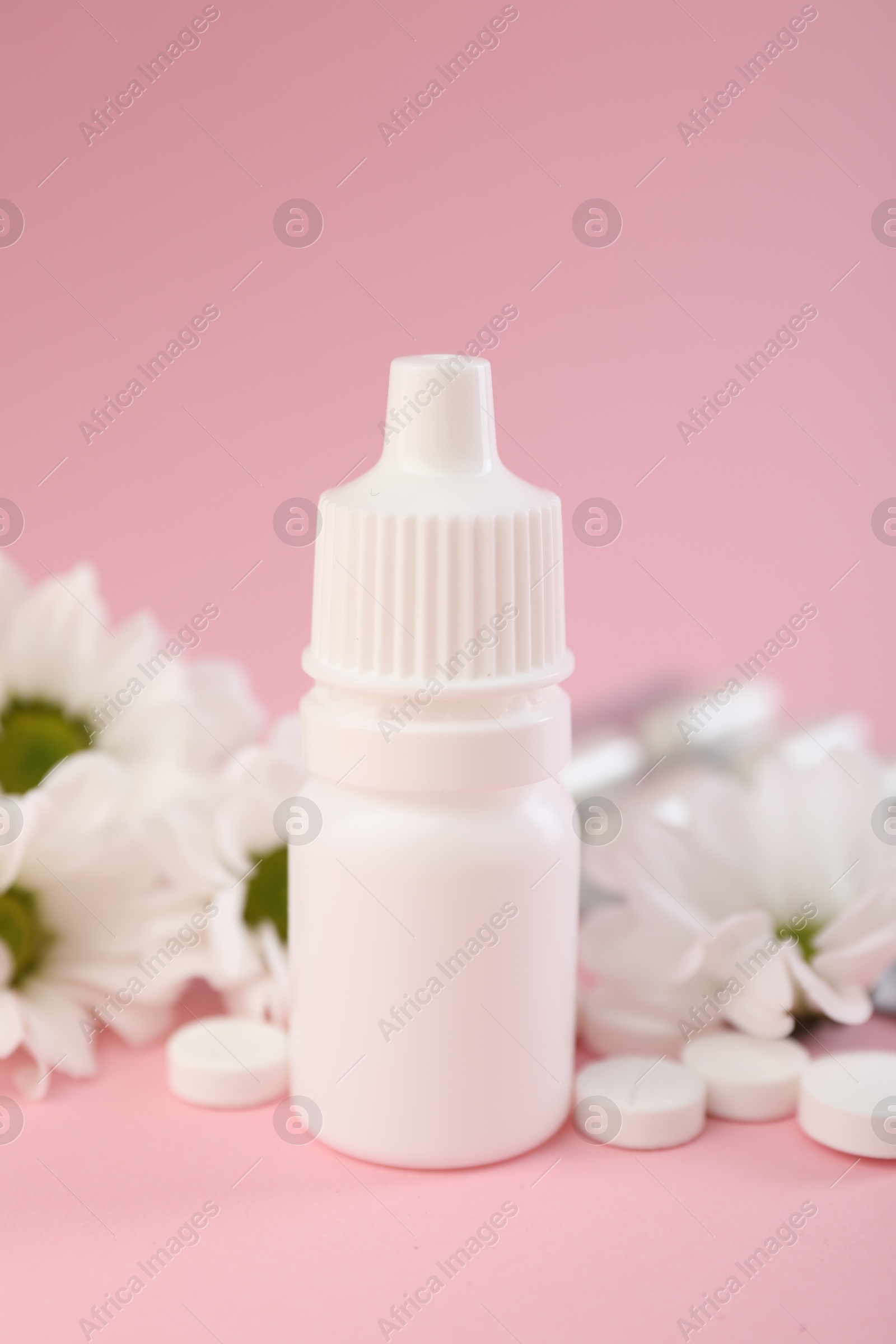 Photo of Allergy treatment. Nasal drops, pills and flowers on pink background, closeup