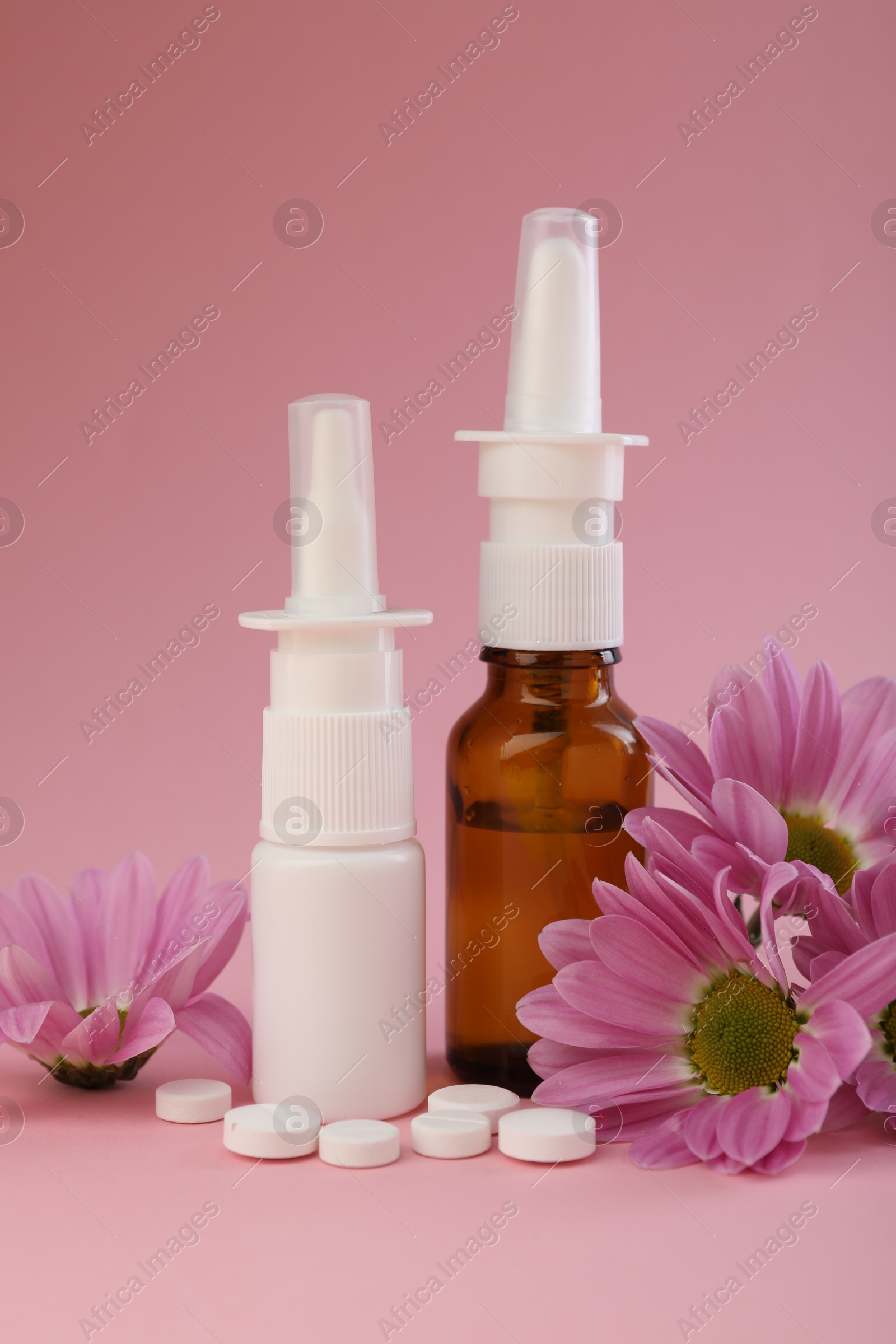 Photo of Allergy treatment. Different medications and flowers on pink background