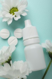 Photo of Allergy treatment. Nasal drops, pills and flowers on light blue background, flat lay