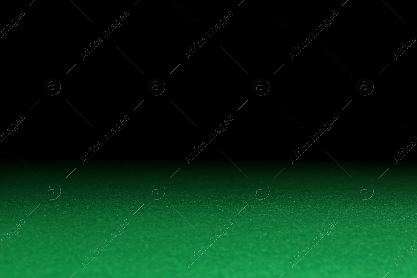 Photo of Green poker table against black background, closeup