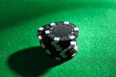 Photo of Stack of poker chips on green table, closeup