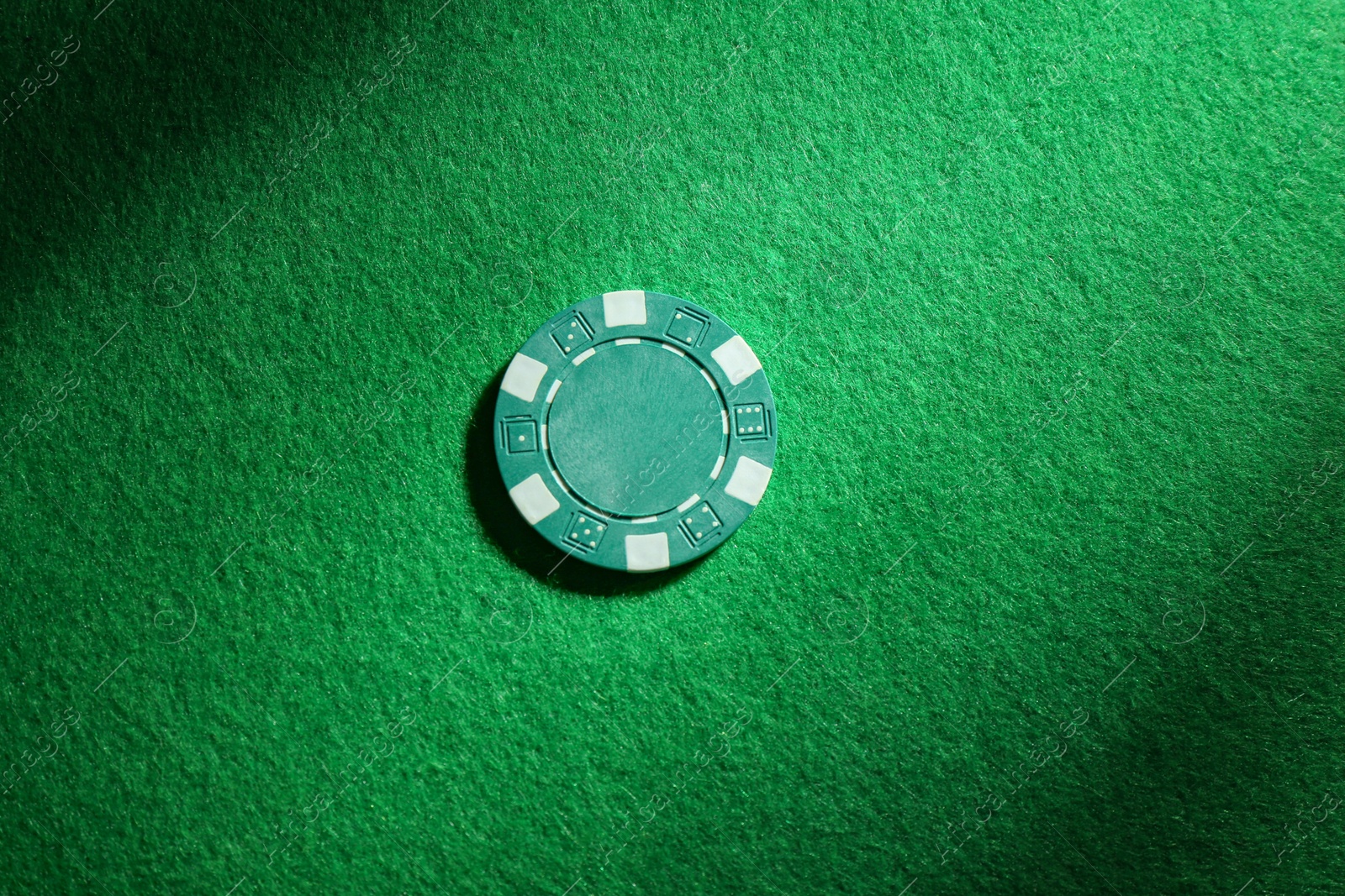 Photo of Poker chip on green table, top view