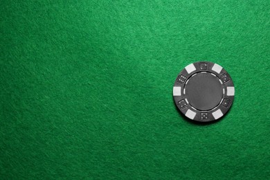 Photo of Poker chip on green table, top view. Space for text