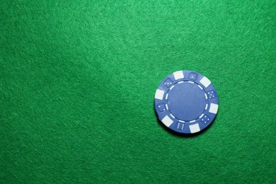 Photo of Poker chip on green table, top view. Space for text