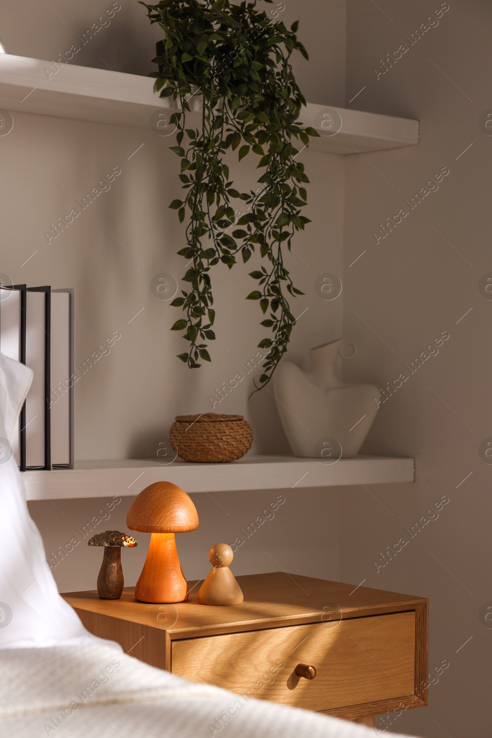 Photo of Stylish living room interior with bed, bedside table and night light