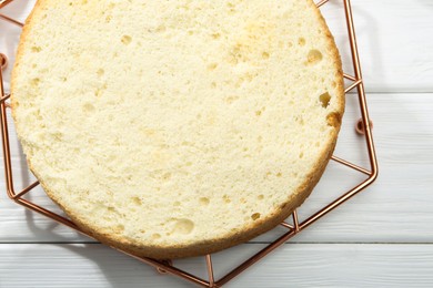 Photo of Delicious cut sponge cake on white wooden table, top view