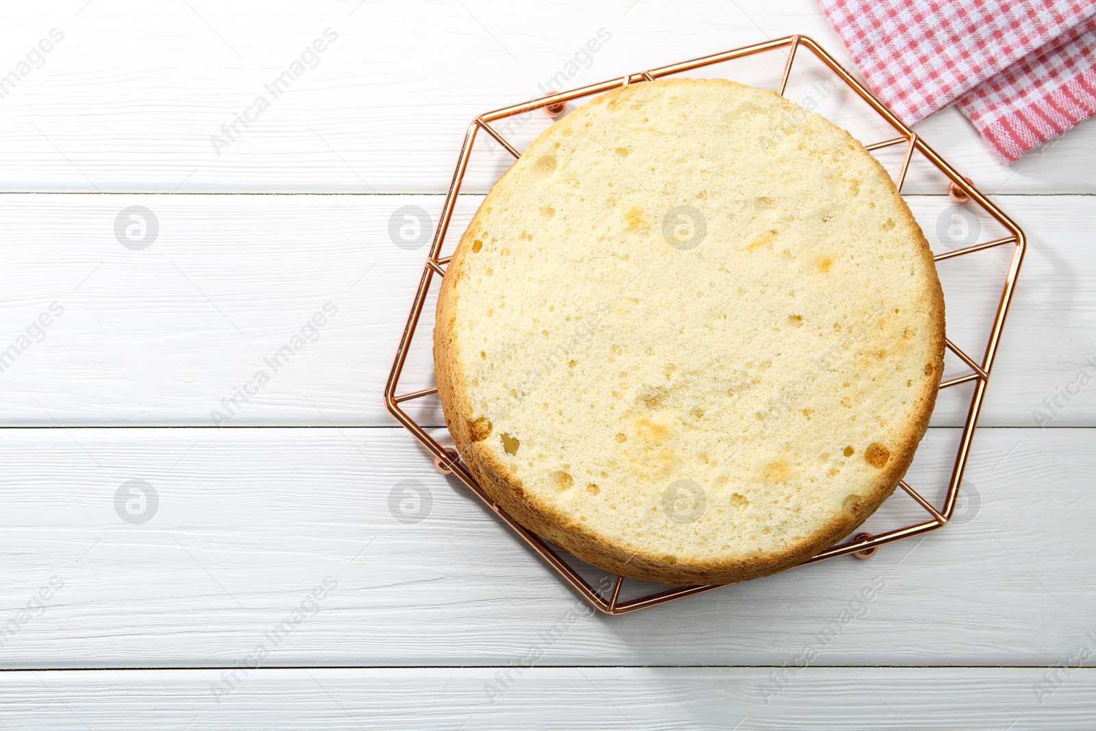 Photo of Delicious cut sponge cake on white wooden table, top view. Space for text