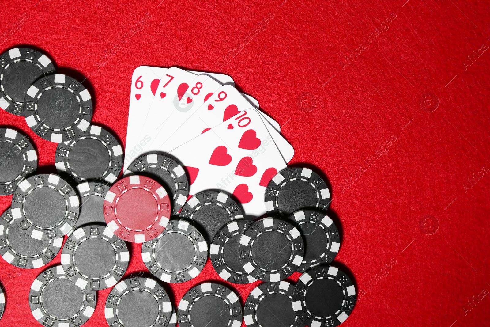 Photo of Playing cards and poker chips on red table, flat lay. Space for text