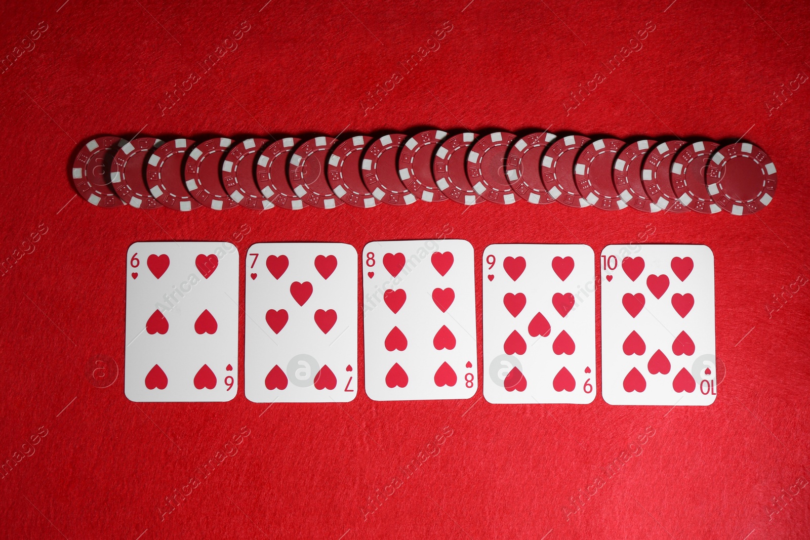 Photo of Playing cards and poker chips on red table, flat lay