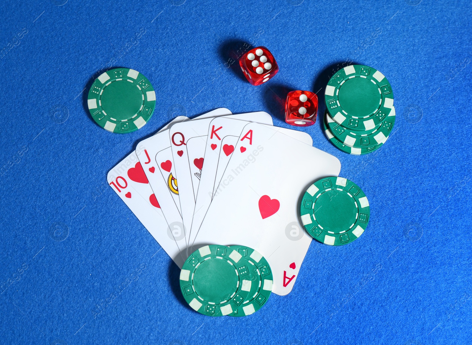 Photo of Playing cards, poker chips and cubes on blue table, flat lay