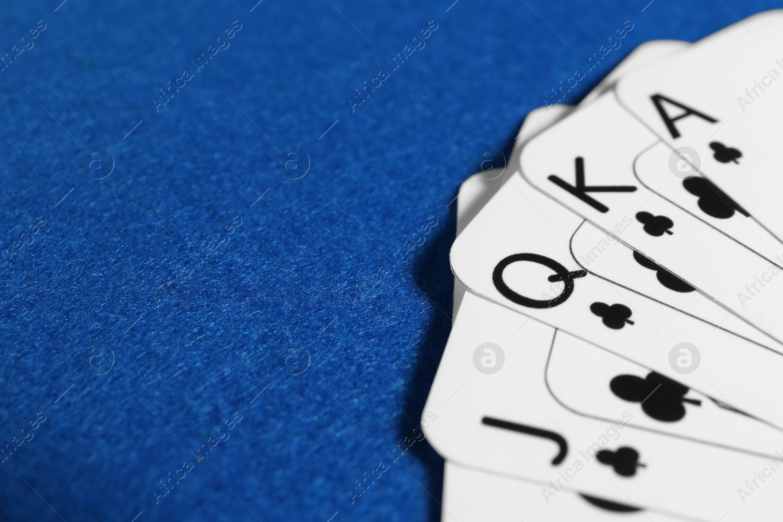 Photo of Poker game. Playing cards on blue table, closeup. Space for text