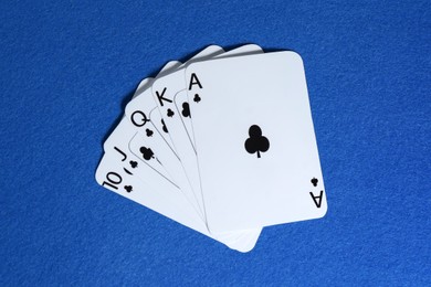 Photo of Poker game. Playing cards on blue table, top view