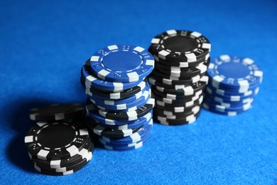 Photo of Poker game. Casino chips on blue table, closeup