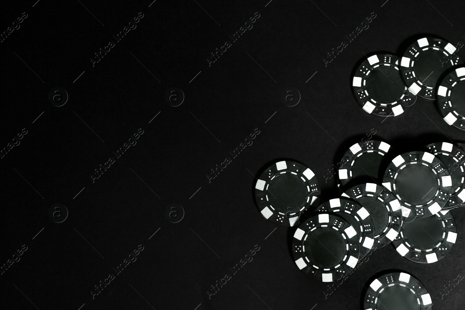 Photo of Poker game. Casino chips on black table, top view. Space for text