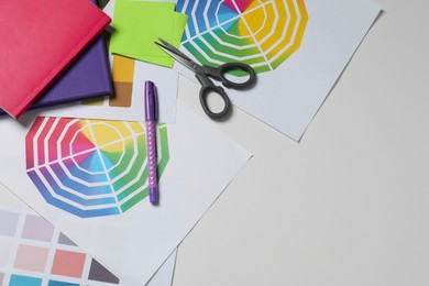 Photo of Designer's workplace with different palettes and stationery on white table, flat lay. Space for text