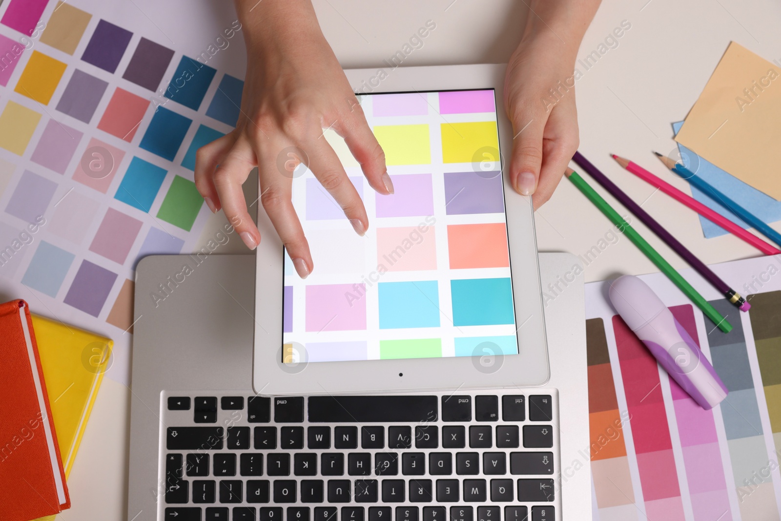 Photo of Website designer working with color palette on tablet at white table, top view