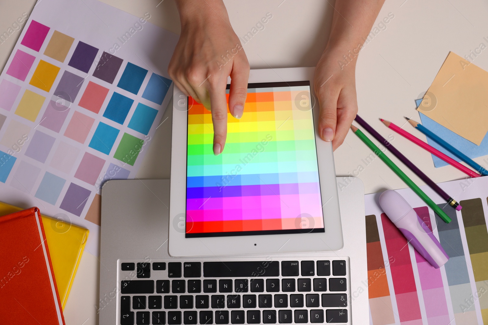 Photo of Website designer working with color palette on tablet at white table, top view