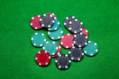 Photo of Poker game. Casino chips on green table, flat lay